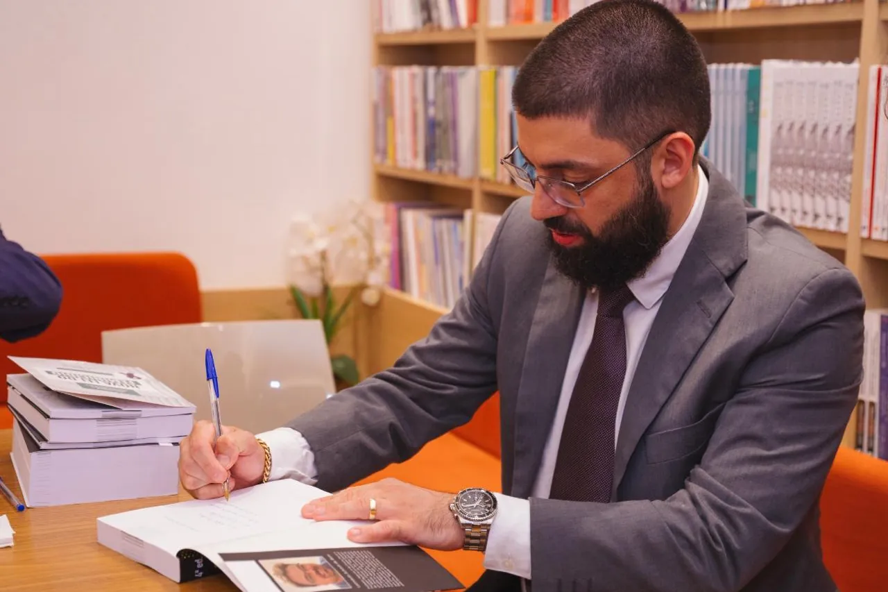 Dr. Evinis Talon autografando um de seus livros durante sessão em biblioteca